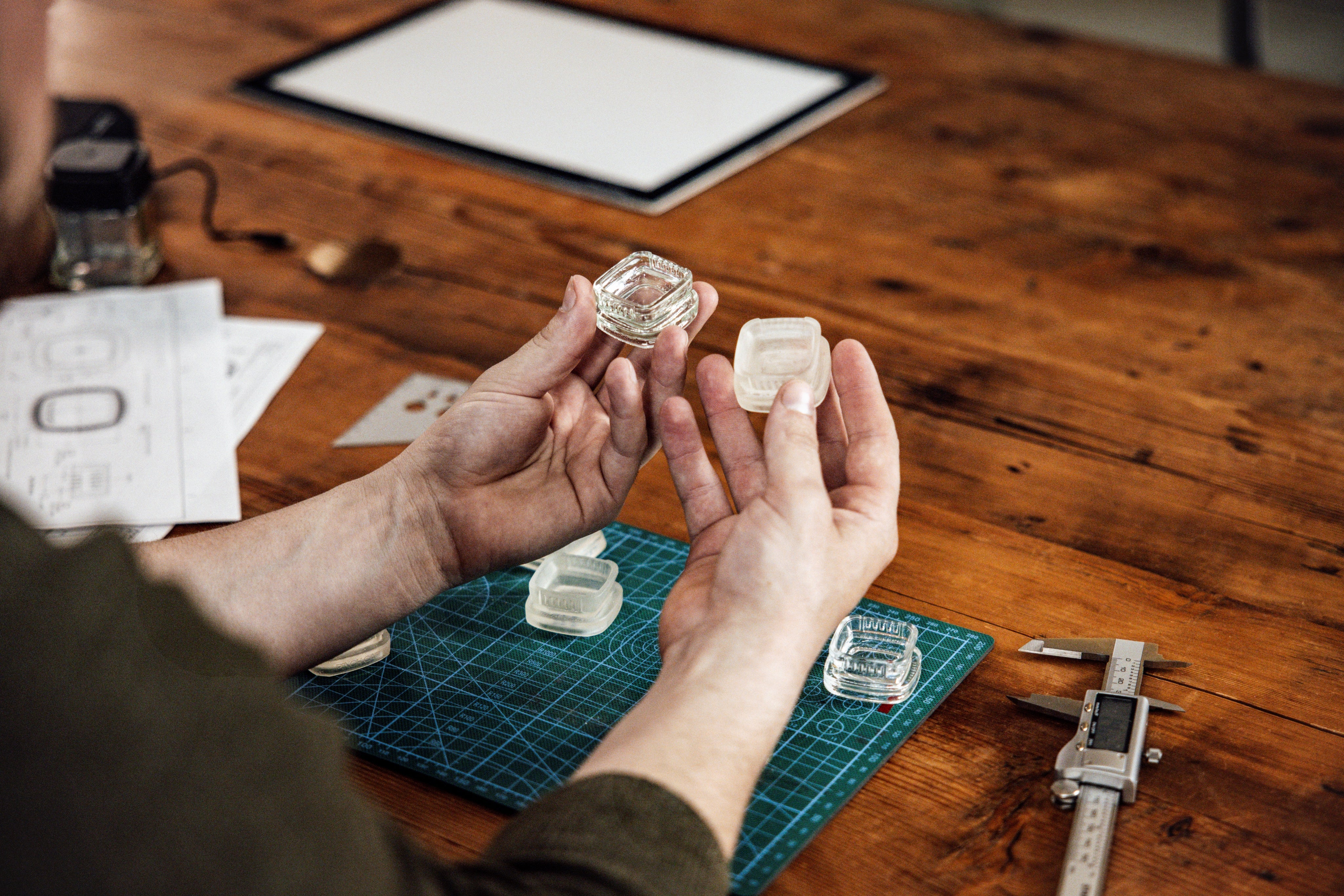 Person holding cannabis concentrate containers at a desk