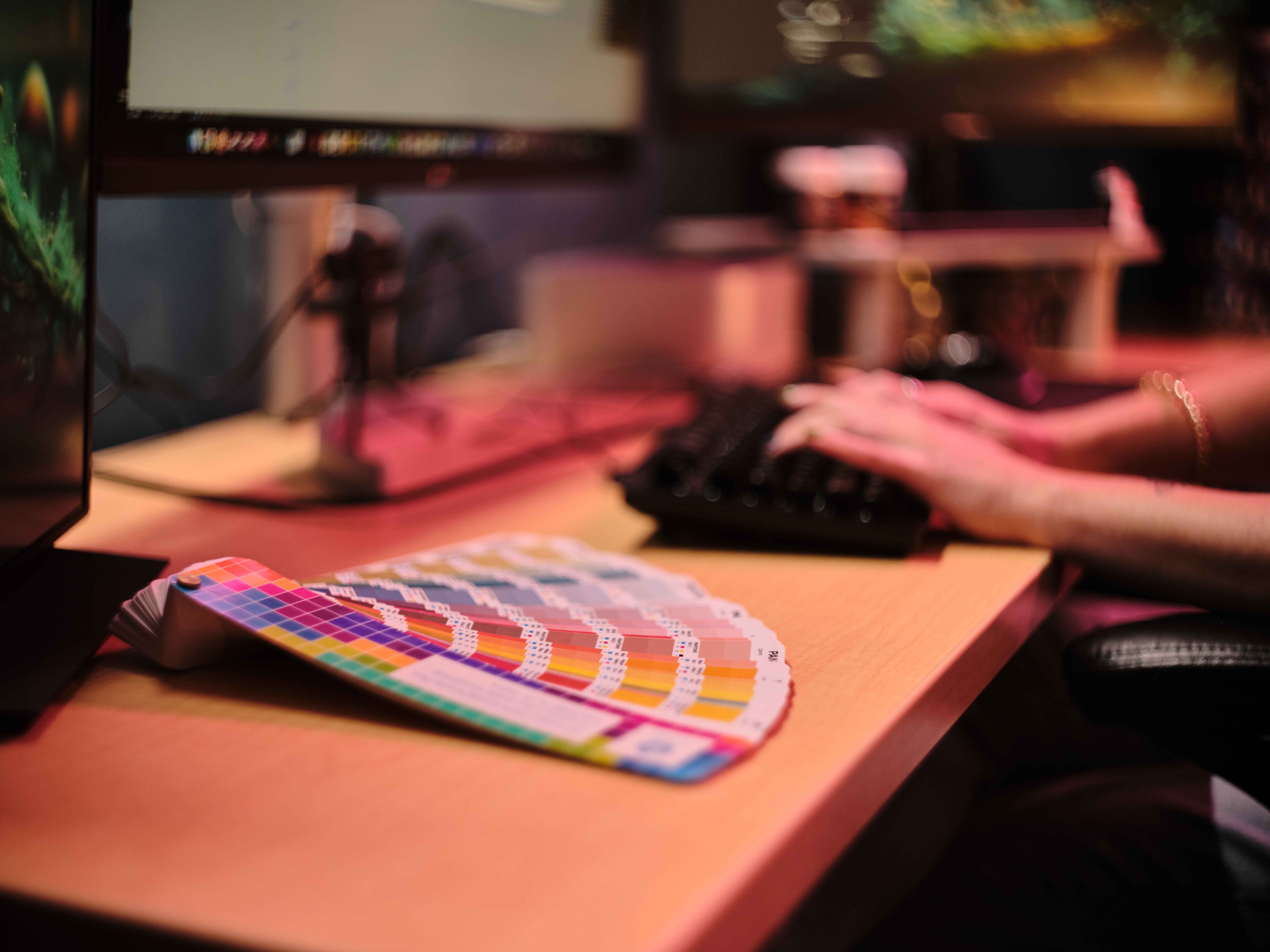 Person using a computer with a colorful card on a desk