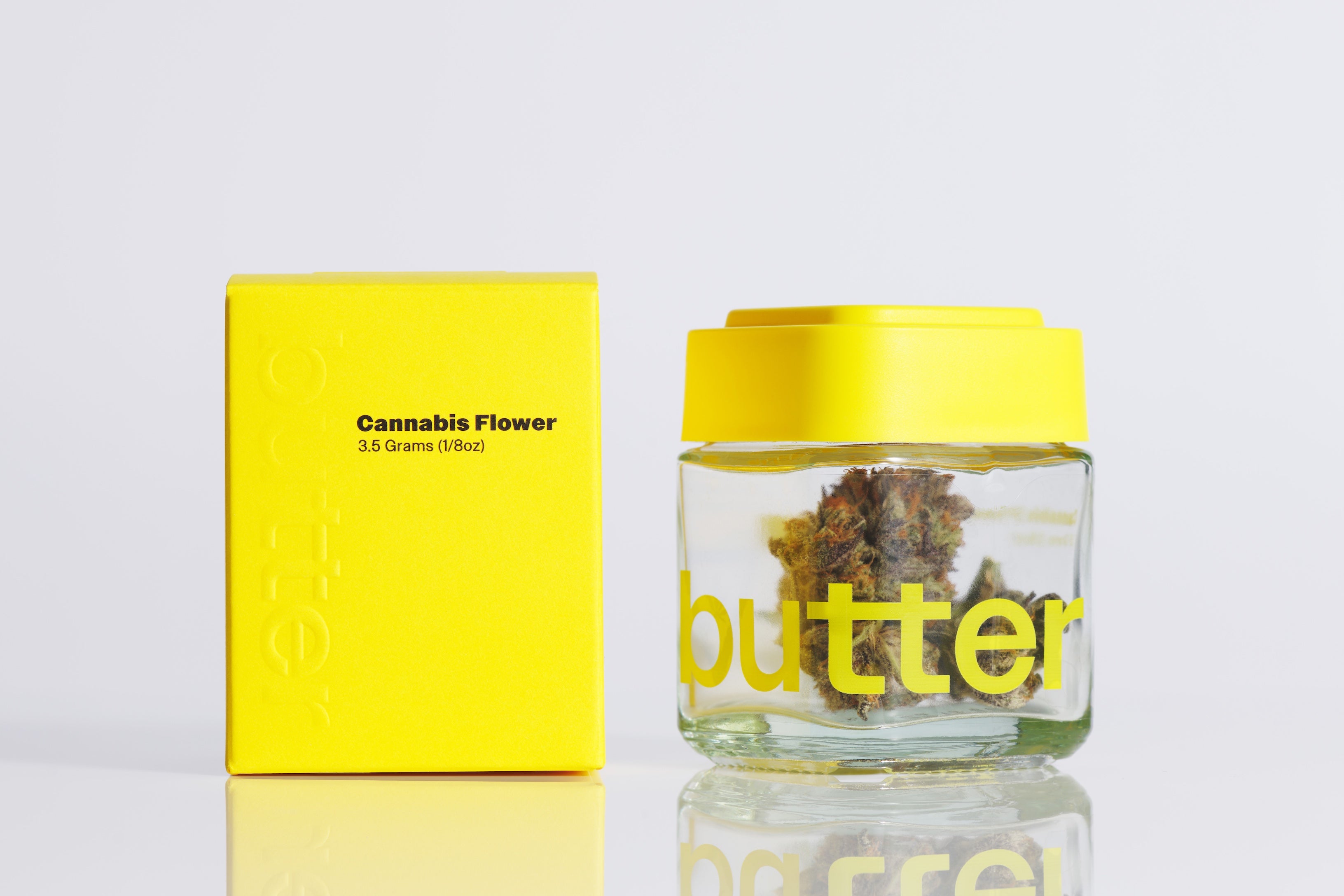 Glass jar with yellow lid and 'butter' branding, containing cannabis flowers, next to a yellow box labeled 'Cannabis Flower'.
