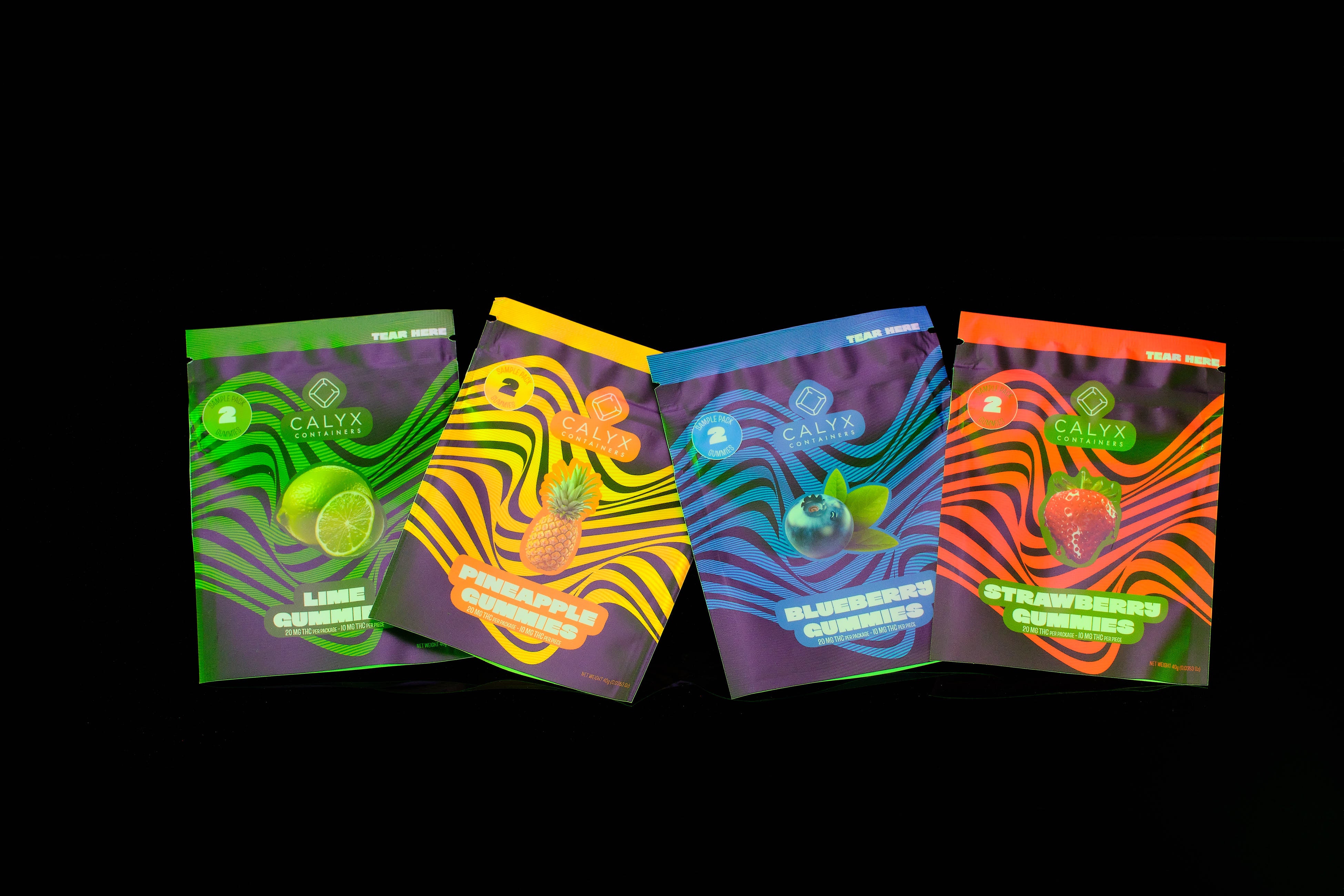 Four custom printed flexible cannabis packaging bags on a black background.