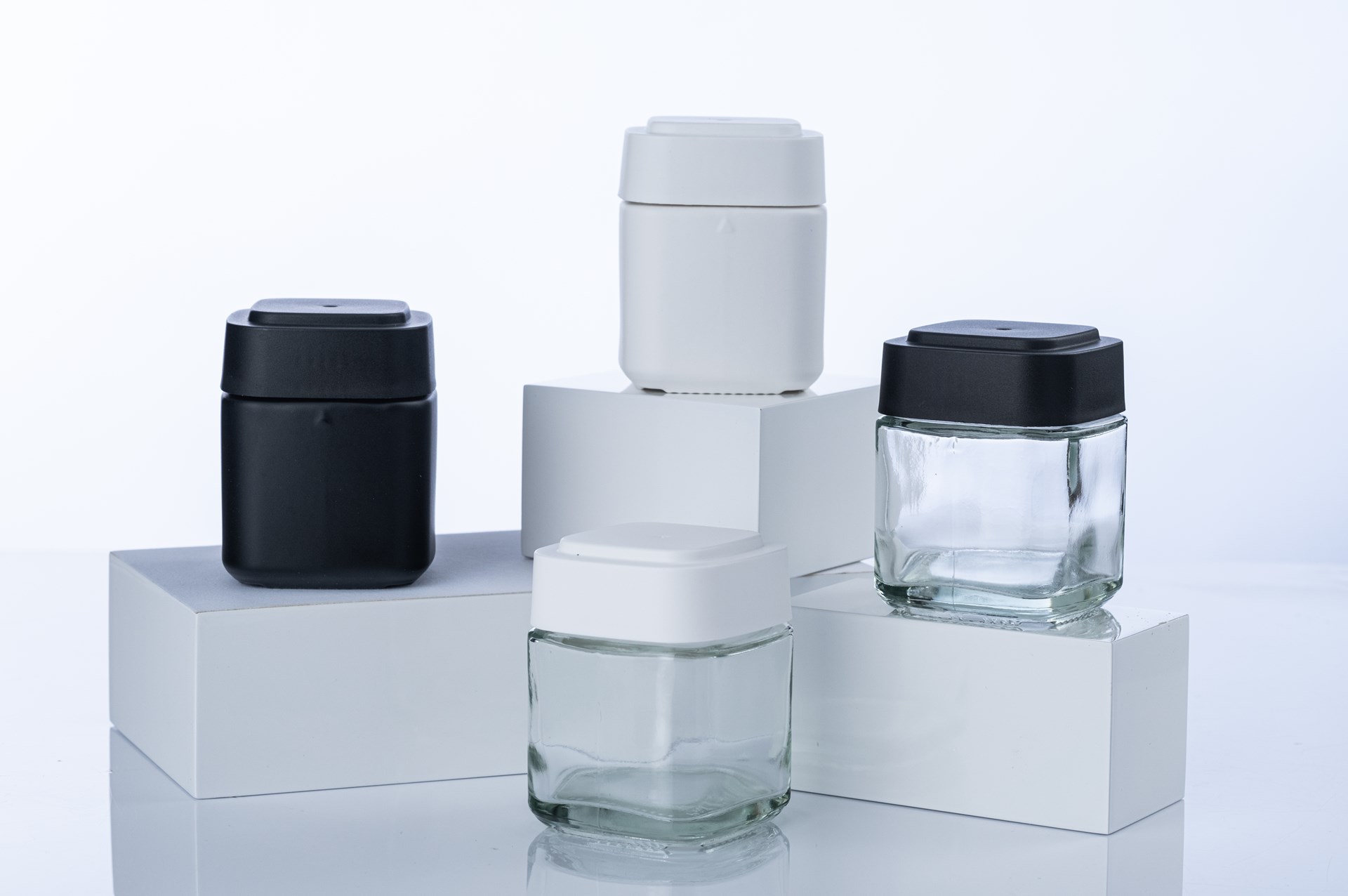 Calyx Jar with black and white lids on clear glass & matte finishes