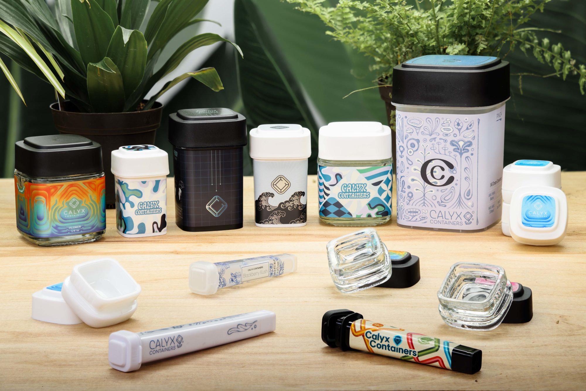 Collection of Calyx Products with customer designs, including the Calyx Jar, Concentrate Containers, Tubes, & Flower Containers