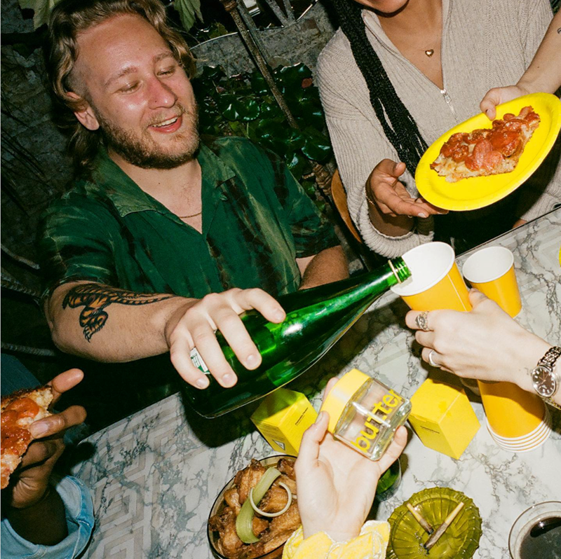 Friends eating and drinking with Calyx drams and joints on the table