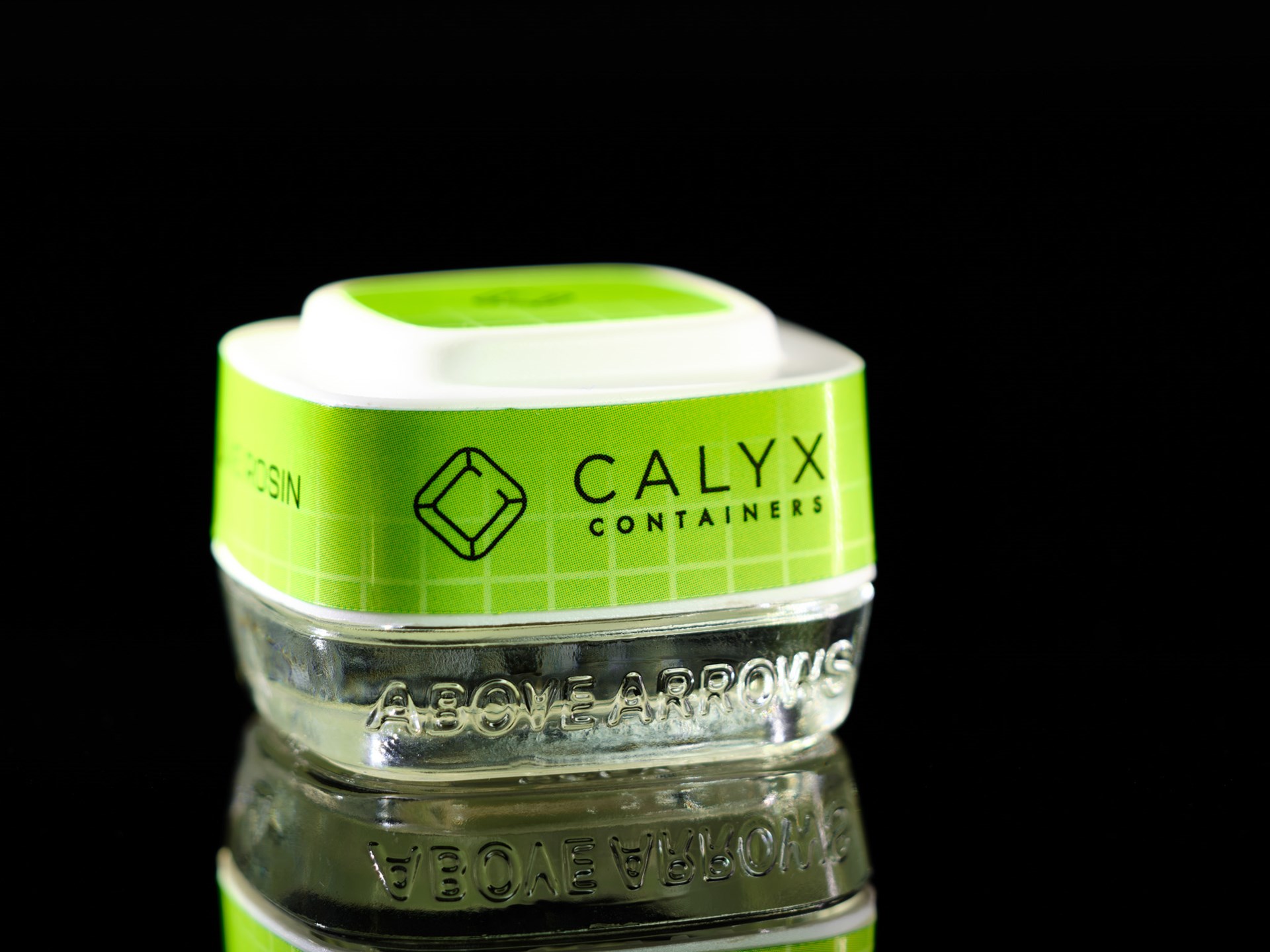 Close-up of a Calyx cannabis concentrate container with bright green Calyx branding