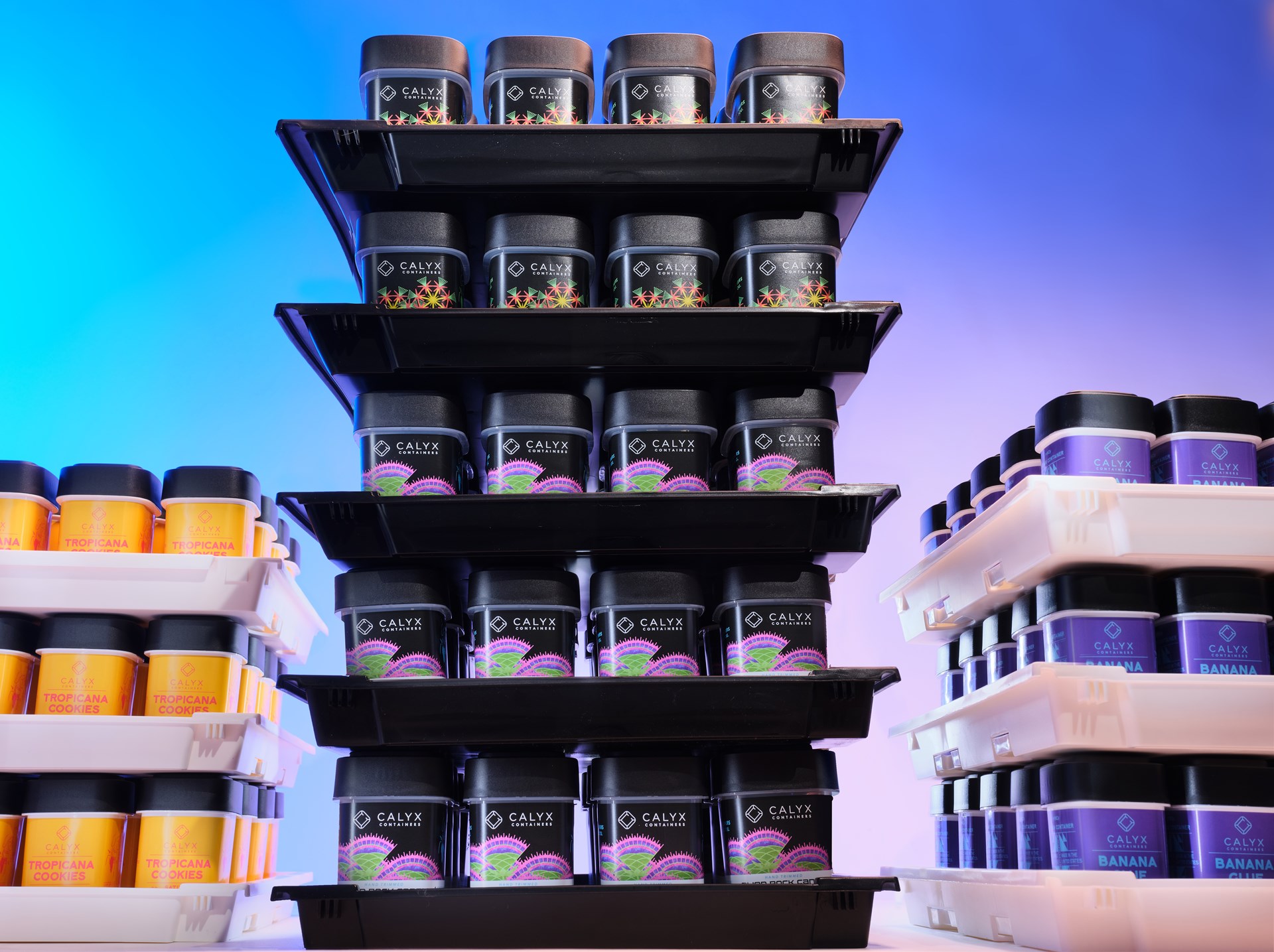 Three stacks of Calyx dram containers with different custom branding